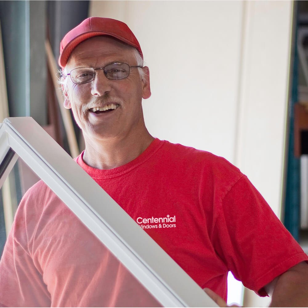 Centennial Windows and Doors Employee Smiling as He Installs Custom Window